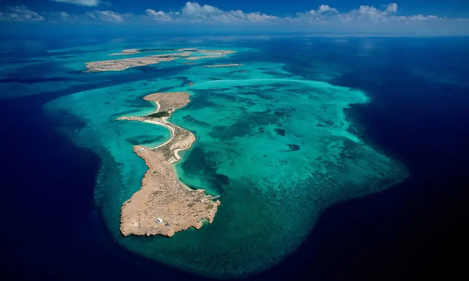 Vue sur la plaine de sel du lac Assal encadrée par des reliefs volcaniques noirs de la dépression de l'Afar
