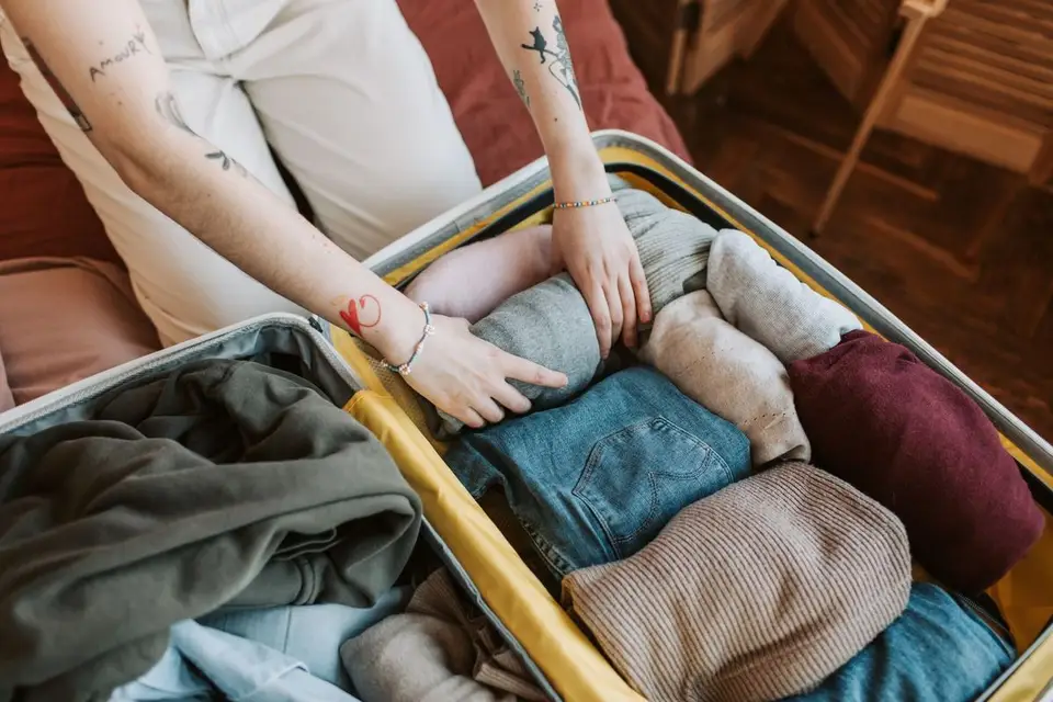 Vêtements rangés un à un dans une valise ouverte, préparés pour le départ